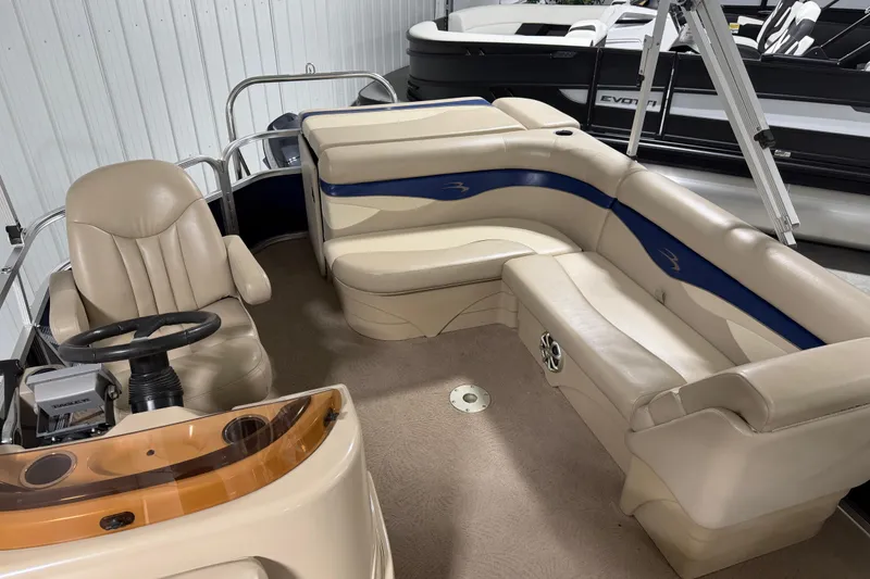 Slide: The Image of 2010 Bennington 20 SLI pontoon boat interior with beige seating and steering console. - 9