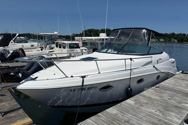 Slide: The Image of 2020 Rinker 270 Express Cruiser docked at marina on a sunny day. - 2