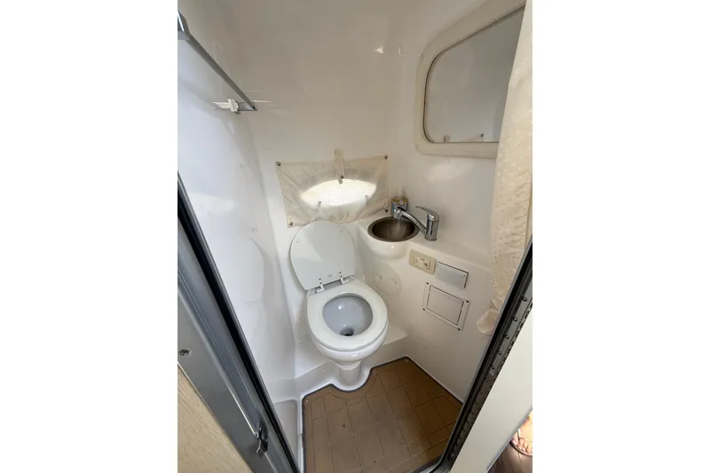 Slide: The Image of Compact bathroom in 2020 Rinker 270 Express Cruiser with toilet and sink. - 18