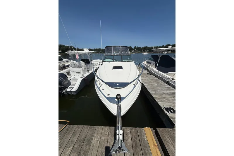 Slide: The Image of 2020 Rinker 270 Express Cruiser docked at marina under clear blue sky. - 6