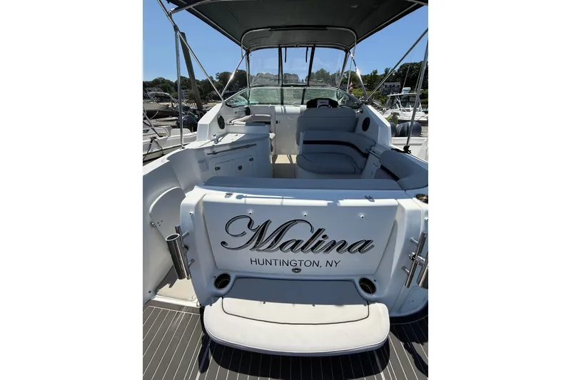 Slide: The Image of 2020 Rinker 270 Express Cruiser boat interior, featuring seating and helm, docked in Huntington, NY. - 11