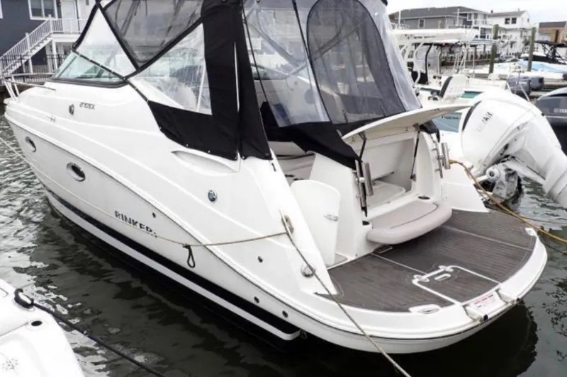 Slide: The Image of 2020 Rinker 270 Express Cruiser docked, featuring sleek design and spacious deck area. - 3