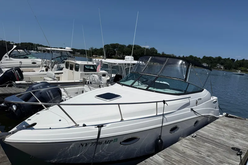 Slide: The Image of 2020 Rinker 270 Express Cruiser docked at a marina under clear blue skies. - 4