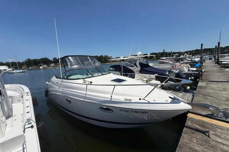 Slide: The Image of 2020 Rinker 270 Express Cruiser docked at a marina under clear blue skies. - 5