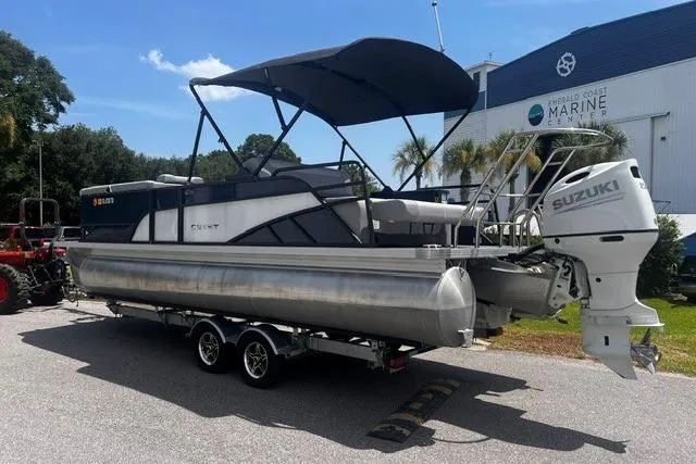 Slide: The Image of 2023 Crest Classic DLX 240 pontoon boat with Suzuki outboard motor on trailer. - 4