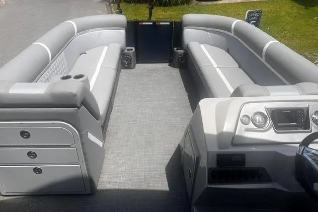 Slide: The Image of 2023 Crest Classic DLX 240 pontoon boat interior with gray seating and modern dashboard. - 16
