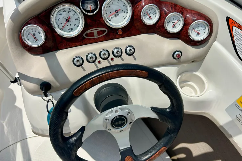 Slide: The Image of Steering wheel and dashboard of a 2013 Tahoe Q4i boat with gauges and controls. - 6