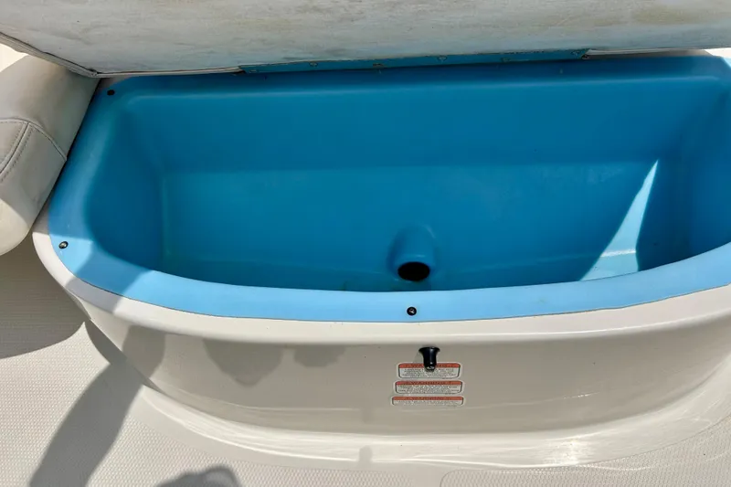 Slide: The Image of Open storage compartment in a 2013 Tahoe Q4i boat, featuring a blue interior. - 20