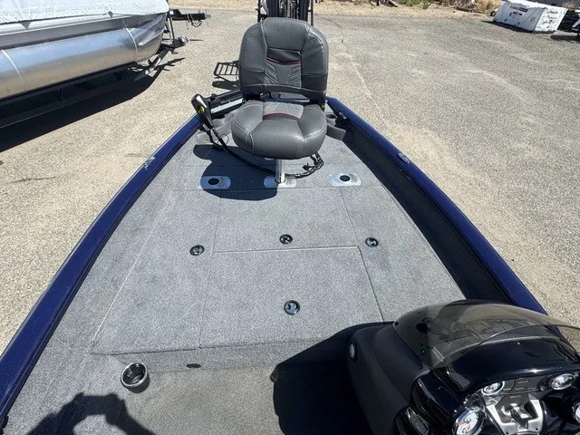 Slide: The Image of The image shows the deck of a 2021 Tracker Pro Team 175 TF boat with gray carpeting and a seat. - 24