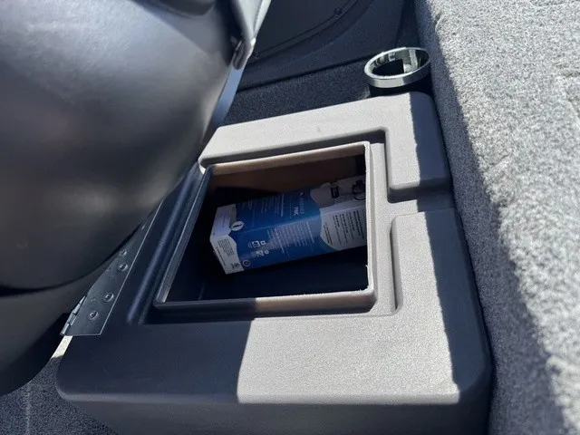 Slide: The Image of A cup holder and compartment with a drink carton on a gray carpeted surface. - 29