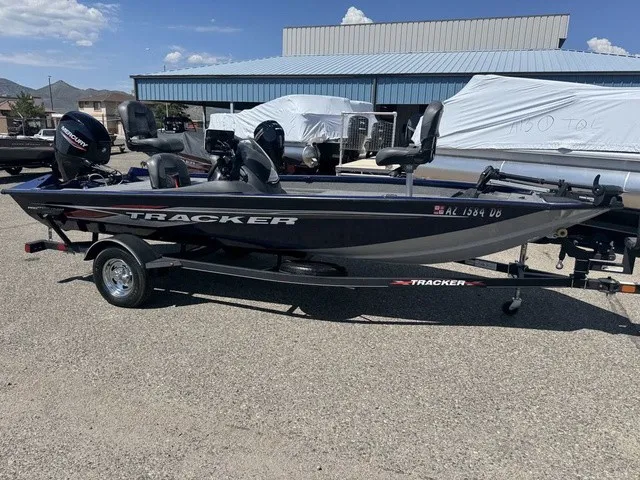 Slide: The Image of 2021 Tracker Pro Team 175 TF on a trailer, featuring two outboard motors, in an outdoor storage area. - 4