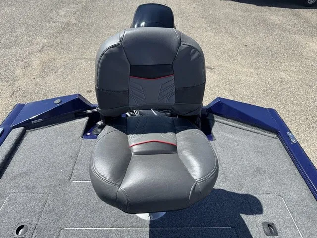 Slide: The Image of A gray padded seat on a boat with blue edging and gray flooring. - 23
