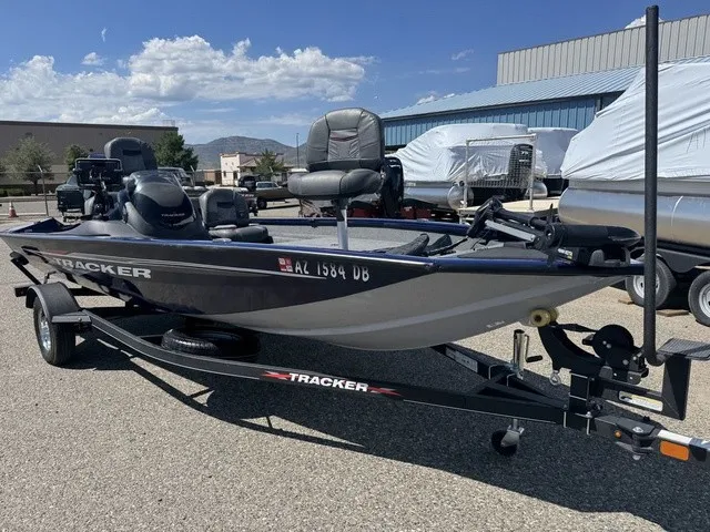 Slide: The Image of A 2021 Tracker Pro Team 175 TF boat on a trailer, parked in a lot under sunny skies. - 18