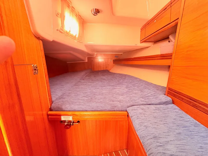 Slide: The Image of The cabin of a 2008 Bavaria Cruiser 38 with wood paneling and blue upholstery. - 30