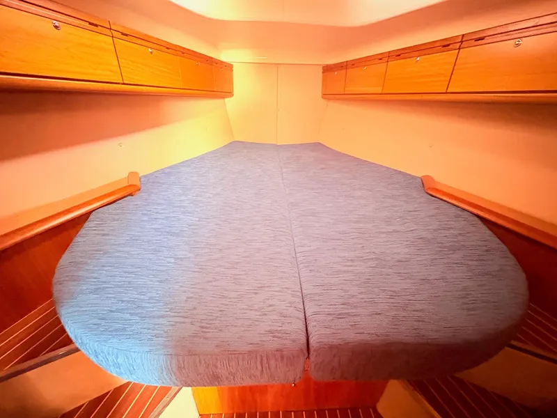 Slide: The Image of The cabin of the 2008 Bavaria Cruiser 38 features a large, comfortable bed with blue upholstery. - 34