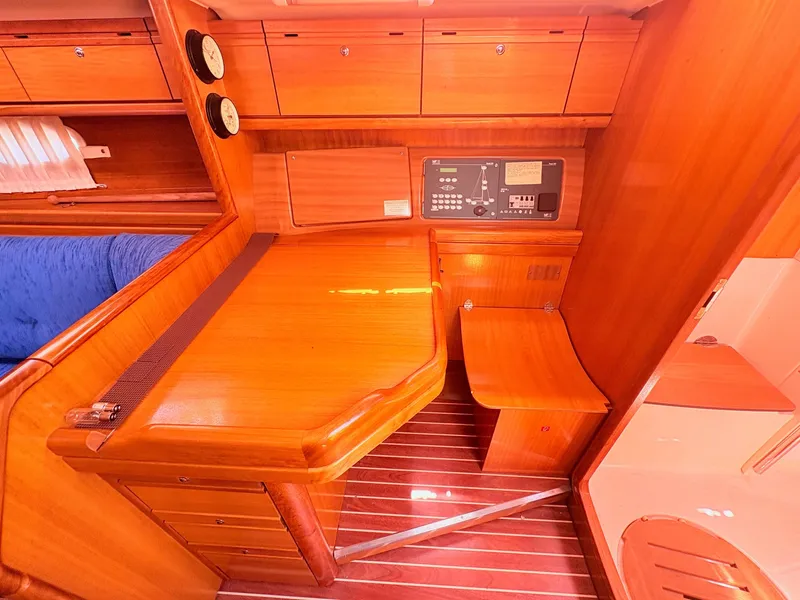 Slide: The Image of Interior of a 2008 Bavaria Cruiser 38 with wooden furnishings and a navigation area. - 23