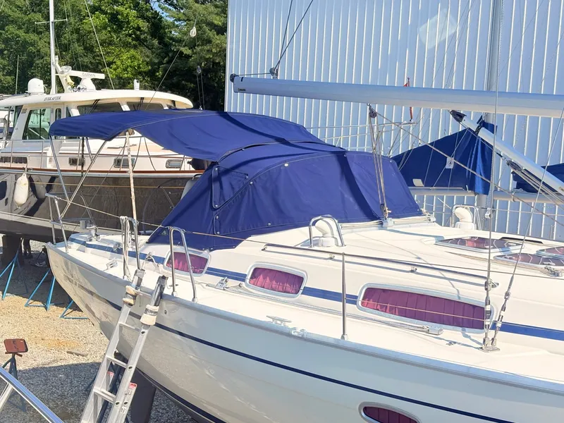 Slide: The Image of A 2008 Bavaria Cruiser 38 with a blue cover, situated on a dry dock. - 2