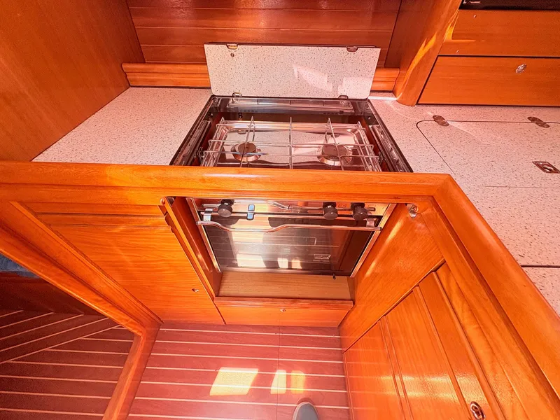 Slide: The Image of The galley of a 2008 Bavaria Cruiser 38 with wood paneling and a built-in oven. - 27
