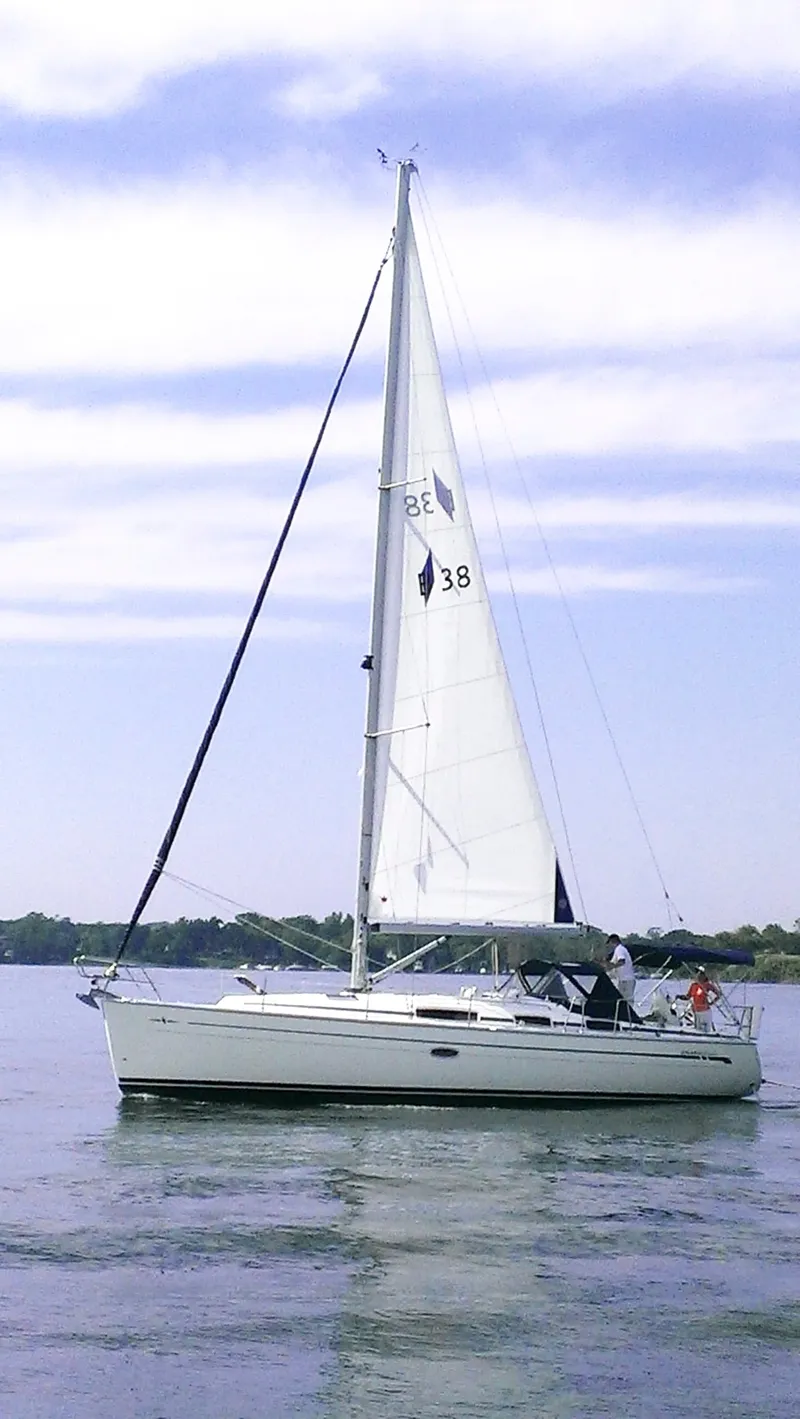 The Image of A white sailing yacht glides on calm waters under a blue sky. - 1