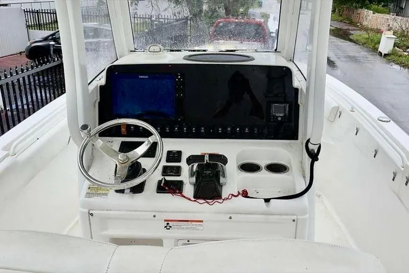 Slide: The Image of 2018 Sea Hunt Gamefish 25 boat console with steering wheel and navigation controls. - 5
