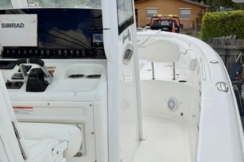 Slide: The Image of 2018 Sea Hunt Gamefish 25 boat interior with Simrad electronics and white seating. - 8