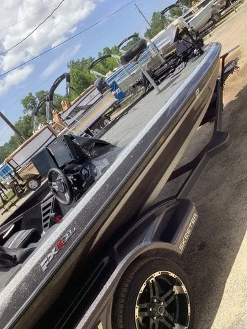 Slide: The Image of A 2023 Skeeter FXR21 boat on a trailer. It features a sleek design and is equipped with electronics. - 49
