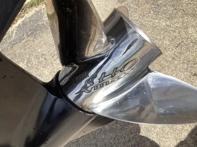 Slide: The Image of Close-up of a shiny boat propeller with Yamaha logo on asphalt. - 4