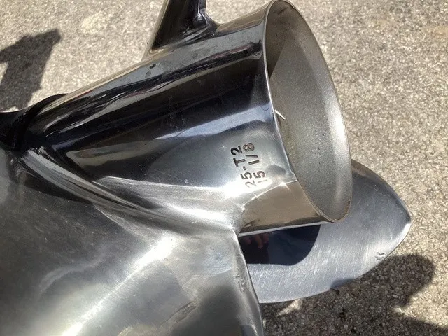 Slide: The Image of Close-up of a shiny boat propeller on a concrete surface. - 5