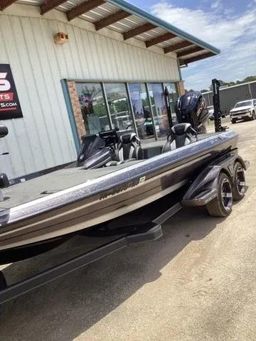 Slide: The Image of A 2023 Skeeter FXR21 bass boat on a trailer outside a building. - 17