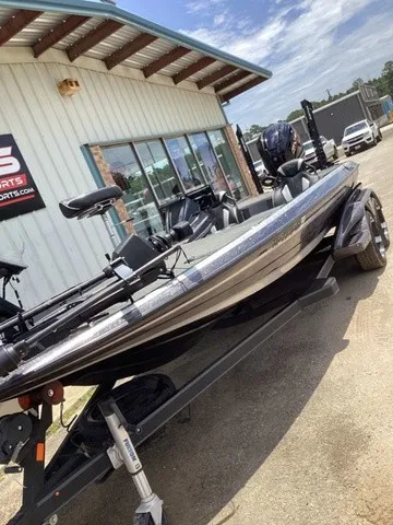 Slide: The Image of A 2023 Skeeter FXR21 boat on a trailer outside a building with large windows. - 18