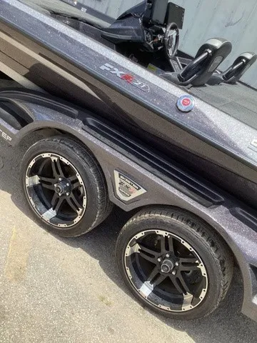 Slide: The Image of A 2023 Skeeter FXR21 boat on a trailer with sleek black rims. - 10