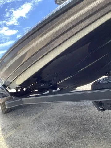 Slide: The Image of The underside of a black boat on a trailer, with a blue sky in the background. - 25