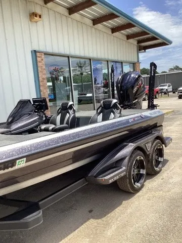 Slide: The Image of A modern 2023 Skeeter FXR21 sits on a trailer outside a building. - 16
