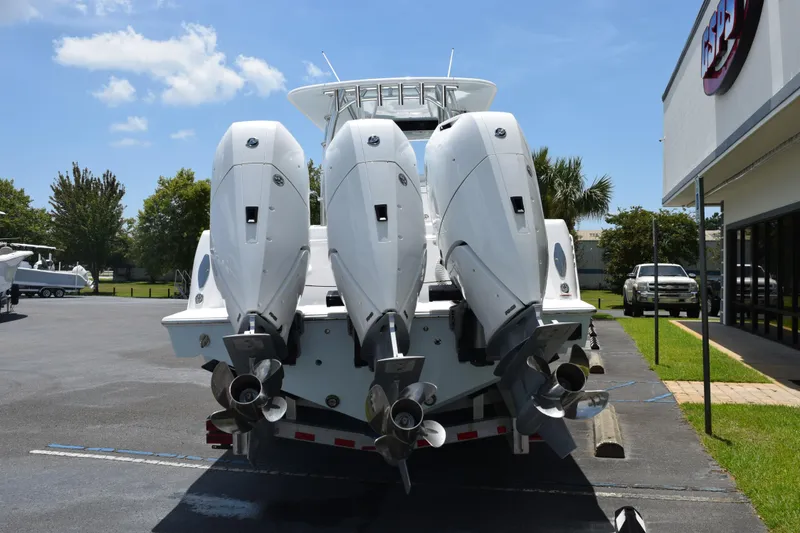 Slide: The Image of 2027 Contender 39 ST boat with triple outboard engines in a parking lot. - 5