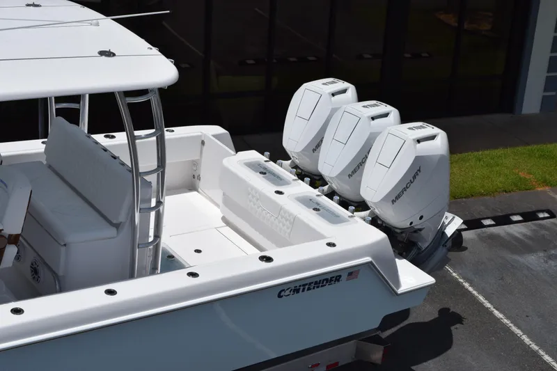Slide: The Image of 2027 Contender 39 ST boat with triple Mercury outboard engines, docked outdoors. - 12