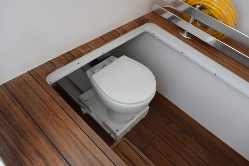 Slide: The Image of Contender 39 ST 2027 boat toilet with wooden flooring and yellow hose. - 19