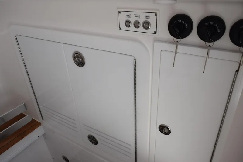 Slide: The Image of Control panel and storage compartments on a 2027 Contender 39 ST boat. - 35