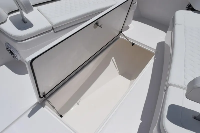 Slide: The Image of Open storage compartment on 2027 Contender 39 ST boat with white seating. - 38