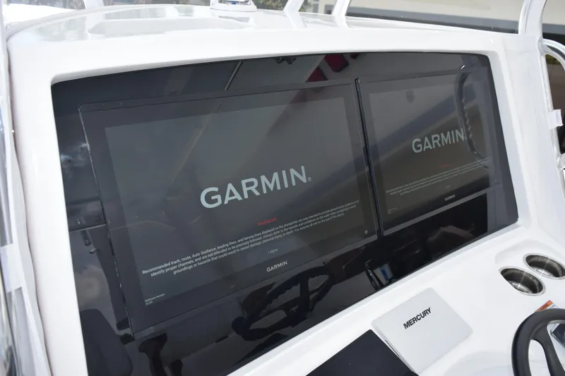 Slide: The Image of Dual Garmin displays on 2027 Contender 39 ST boat dashboard, featuring Mercury controls. - 30