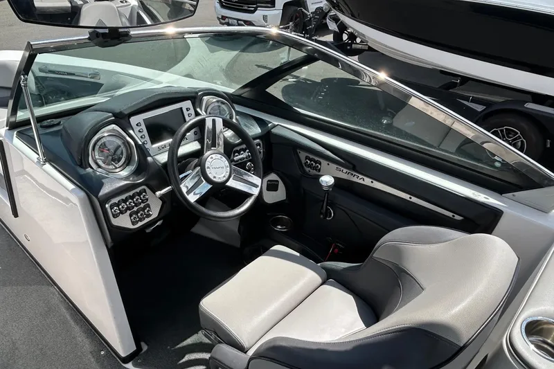 Slide: The Image of Interior of a 2015 Supra SA 400 boat, featuring sleek dashboard and steering wheel. - 11