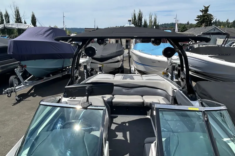 Slide: The Image of 2015 Supra SA 400 boat with sleek design, parked among other boats at a marina. - 15