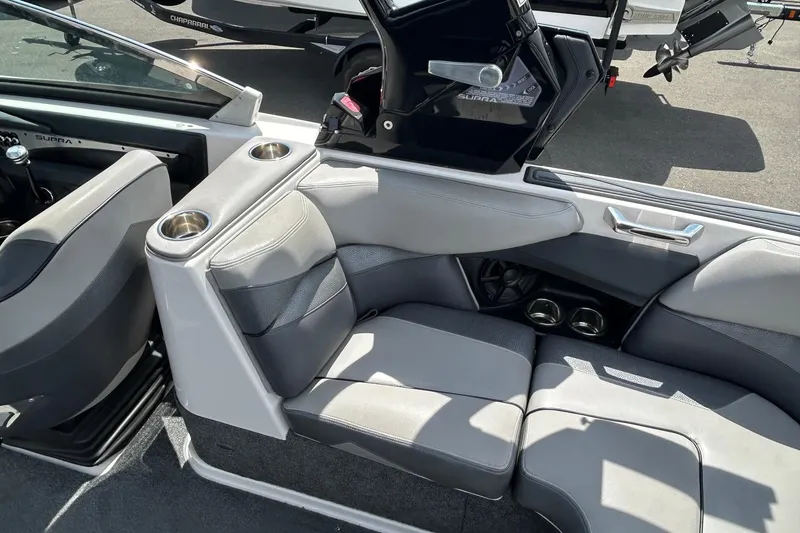 Slide: The Image of Interior of a 2015 Supra SA 400 boat, featuring gray seating and cup holders. - 8