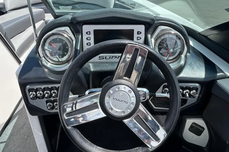 Slide: The Image of Cockpit view of 2015 Supra SA 400 boat with steering wheel and dashboard controls. - 12