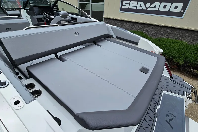 Slide: The Image of 2023 Cobalt R4 boat interior with gray seating and steering wheel, displayed at a showroom. - 7