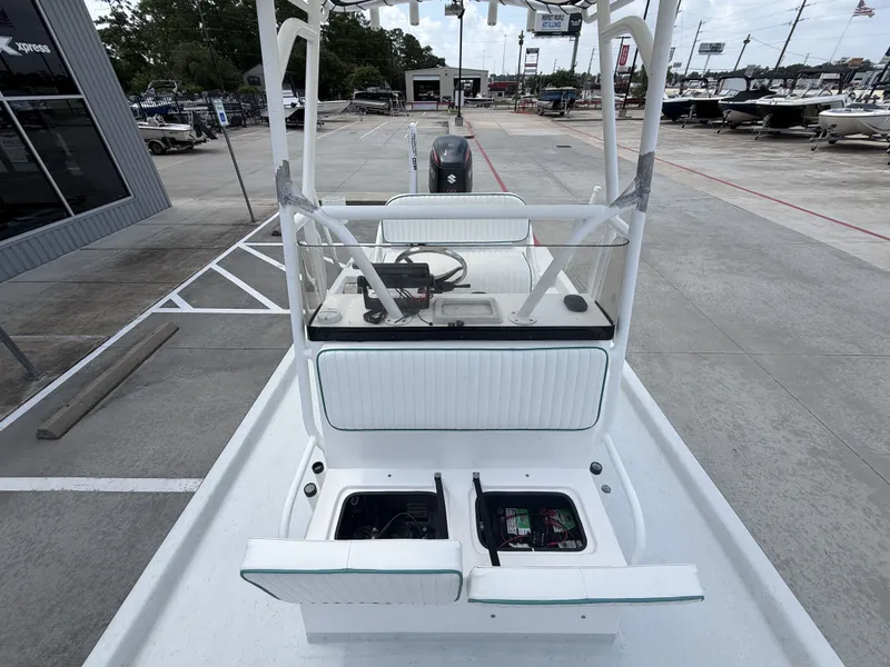 Slide: The Image of The image shows a 2015 Mowdy C-25 boat with open storage and a helm console. - 26