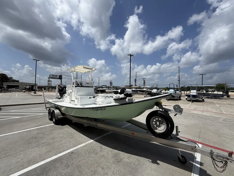 Slide: The Image of A 2015 Mowdy C-25 boat on a trailer in a parking lot under a cloudy sky. - 6