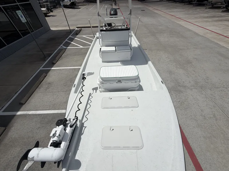 Slide: The Image of A white boat with an open deck, equipped with a motor and storage, is parked on a lot. - 24