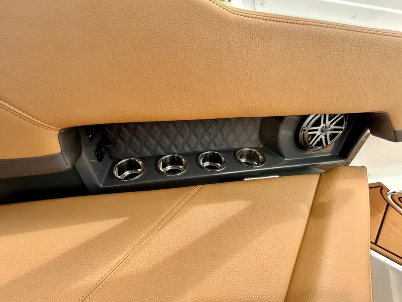 Slide: The Image of Close-up of a boat seat with brown leather, cup holders, and a speaker. - 45