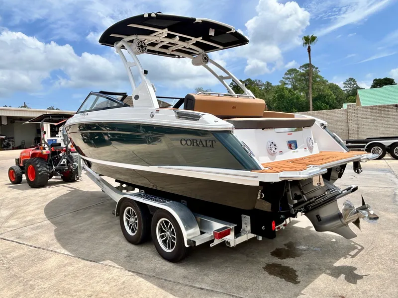 Slide: The Image of A modern Cobalt R4 boat on a trailer, ready for the water. It features a sleek design. - 8