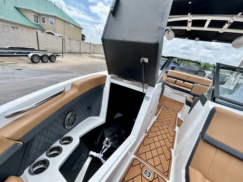 Slide: The Image of The image shows the interior of a 2027 Cobalt R4 boat with brown seats and an open storage compartment. - 23